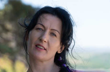 Mature MILF Nimfa Mannay displays her natural pussy beside a dirt road