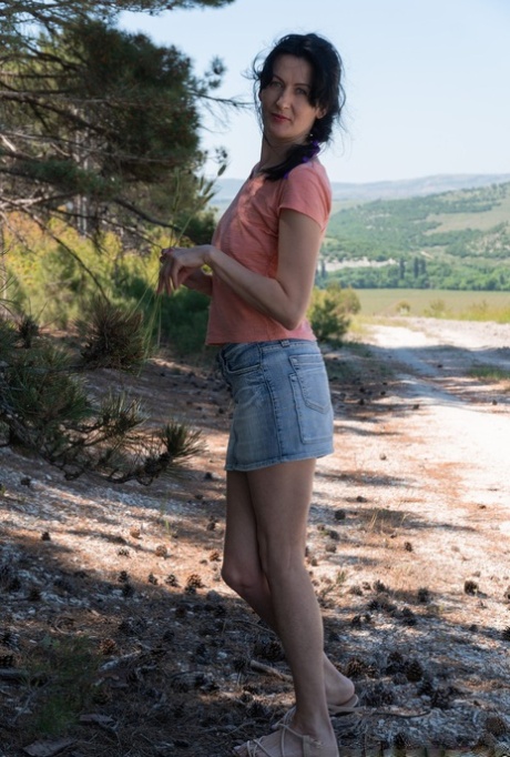Mature MILF Nimfa Mannay displays her natural pussy beside a dirt road