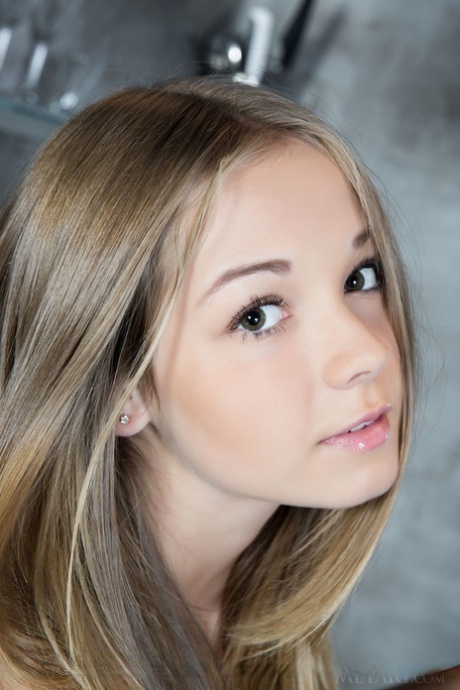 Blonde glamour babe displaying shaved teen pussy and small breasts