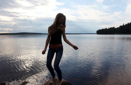 Girl next door Megan pulls out her tits while sitting on a rock in the lake