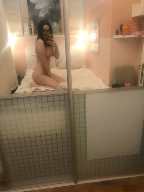 Brunette babe in glasses takes nudes showing her small tits & her shaved twat
