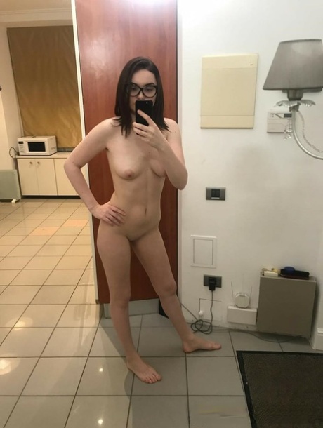 Brunette babe in glasses takes nudes showing her small tits & her shaved twat