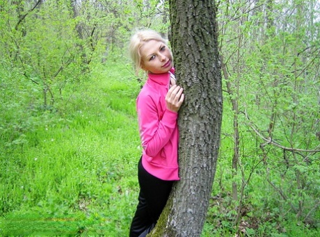 Blonde amateur Adele exposes her boobs and butt while in a forest setting