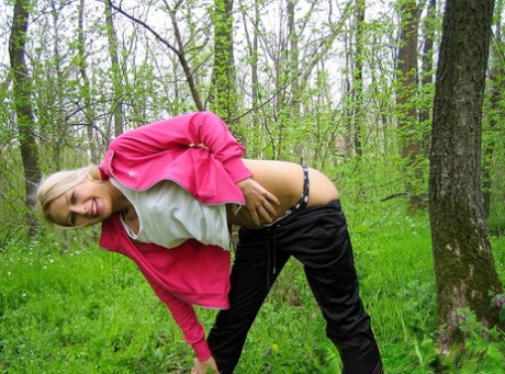 Blonde amateur Adele exposes her boobs and butt while in a forest setting