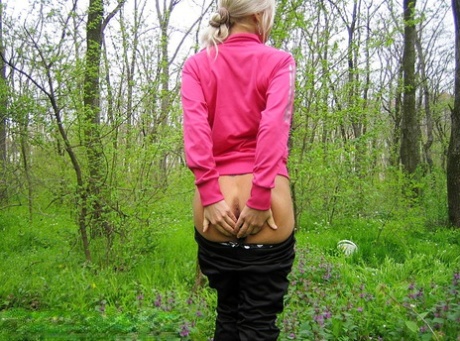 Blonde amateur Adele exposes her boobs and butt while in a forest setting