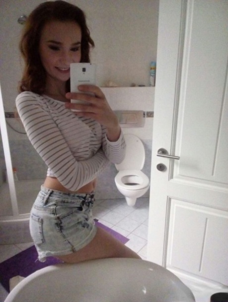 Young redhead Radka takes clothed and topless selfies around her place