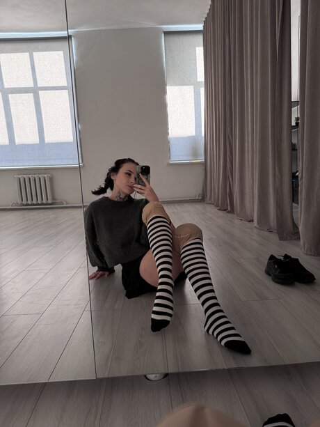 Brunette teen Beatrice Bell shows her tongue while wearing knee socks