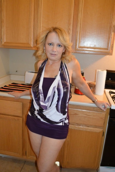 Mature blonde strips in the kitchen & rubs her juicy tits and hot pussy