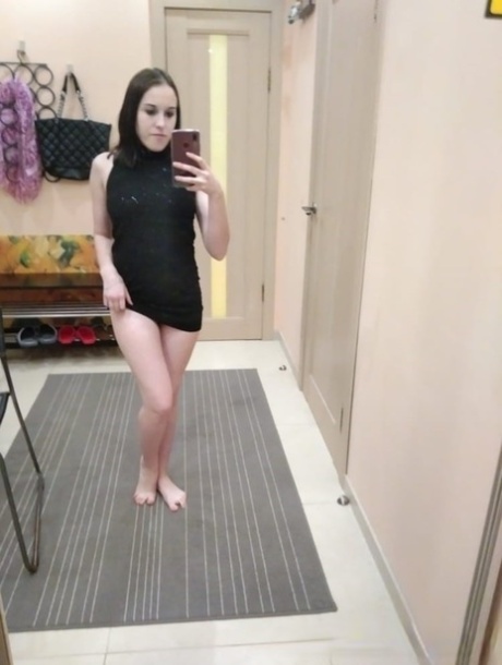 Petite American teen takes selfies while posing in the mirror and stripping