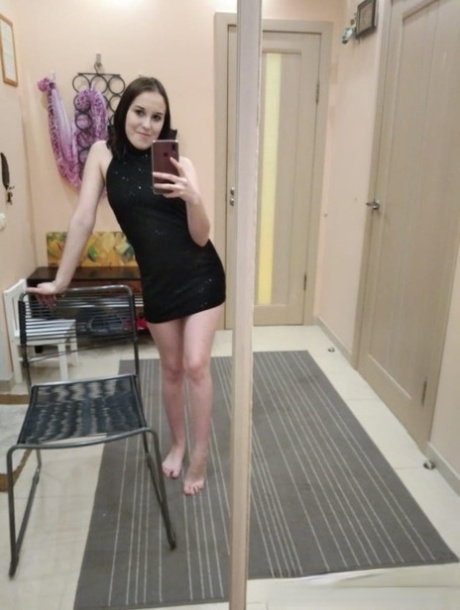 Petite American teen takes selfies while posing in the mirror and stripping