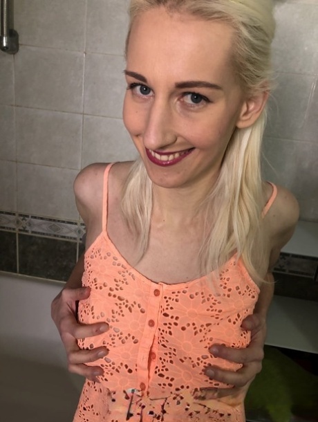 Blonde amateur shows off her saggy breasts and her big clit in the bathroom