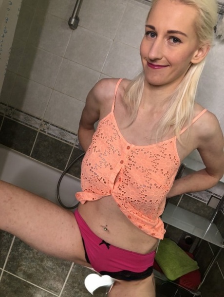 Blonde amateur shows off her saggy breasts and her big clit in the bathroom
