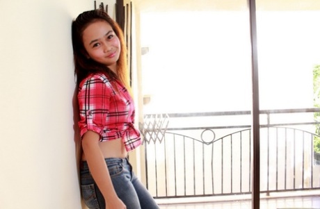 Asian teenager in blue jeans undresses to pose in the nude for the first time