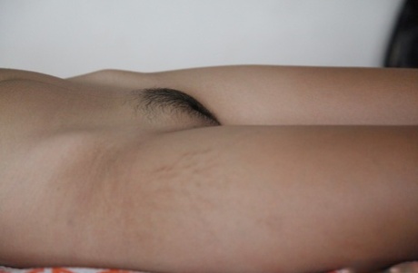 Skinny Asian spinner Lynn displays her small tits and innie pussy on the bed