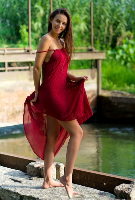 Beautiful teen Alisa Amore disrobes for nude solo poses near a dam