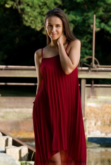 Beautiful teen Alisa Amore disrobes for nude solo poses near a dam