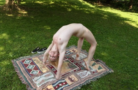Cute blonde Emma Starletto shows off her flexibility while naked in the yard