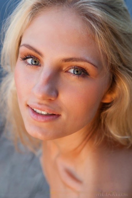 Young blonde female Jaime A stripping off clothes to model naked outdoors