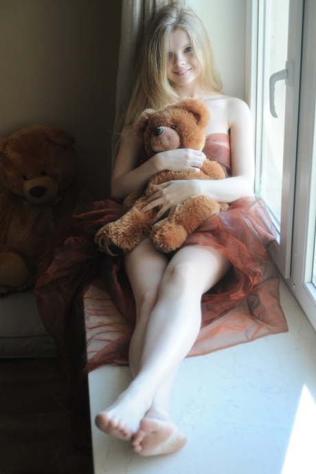 Tiny teen Kisa strikes tempting nude poses while holding a teddy bear