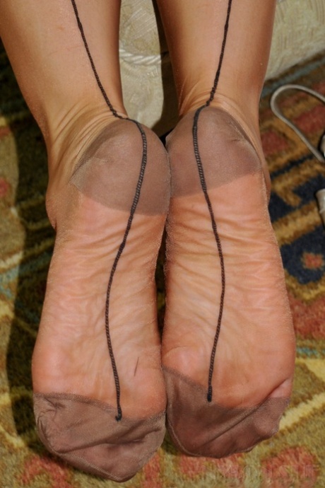 Classy mature blonde shows her tits and twat in back seamed nylons