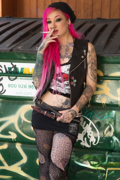 Smoking tattooed Kelsi Lynn in ripped pantyhose flaunting naked ass in alley