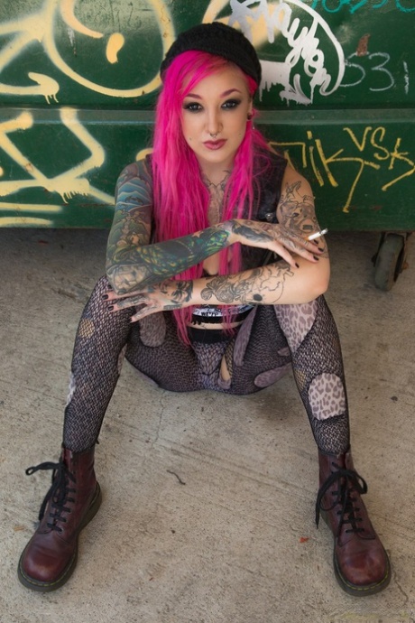 Smoking tattooed Kelsi Lynn in ripped pantyhose flaunting naked ass in alley