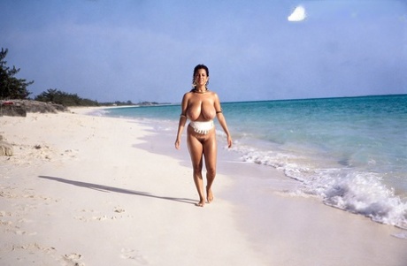 Busty MILF Devon Daniels gets her massive melons covered in sand at the beach