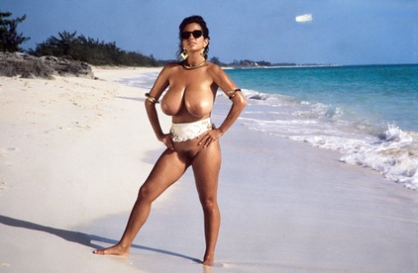 Busty MILF Devon Daniels gets her massive melons covered in sand at the beach