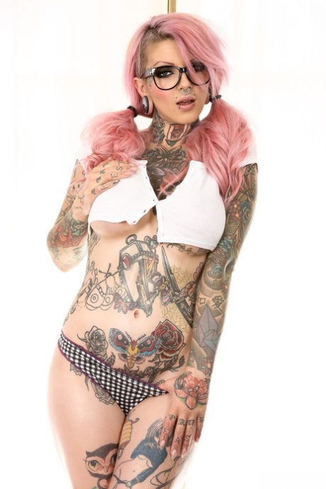Tattooed emo babe with glasses uncovering her big fake tits and shaved cunt