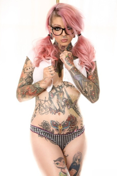 Tattooed emo babe with glasses uncovering her big fake tits and shaved cunt