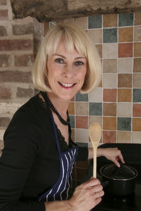 Lusty mature housewife undressing and teasing her hairy slit in the kitchen