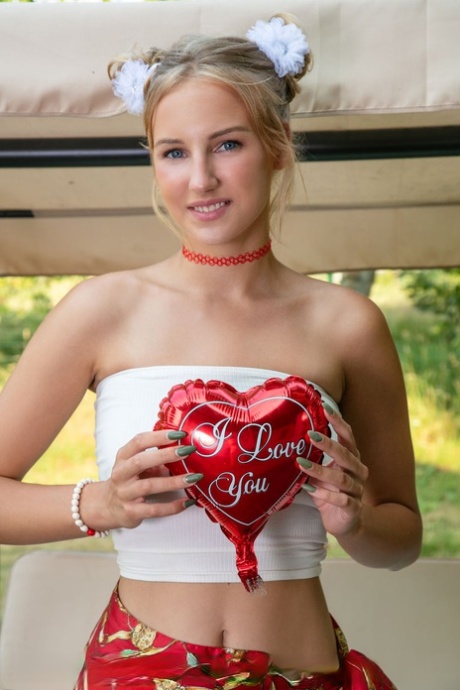 Beautiful blonde teen Nana gets naked on a bench swing while wearing a choker