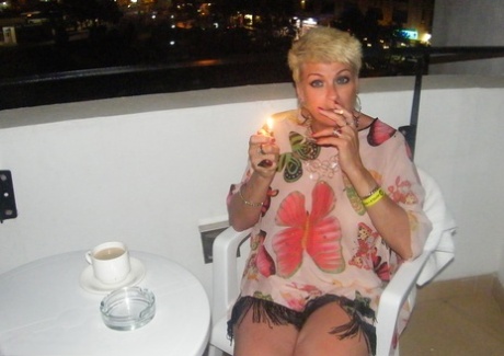 Sexy mature woman Dimonty gets naked after smoking a cigarette on balcony