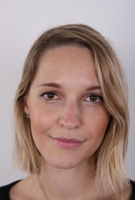 European female Tereza wears no expression while undressing for rent money