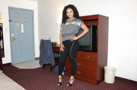 Curly-haired ebony chick with ample booty slowly getting rid of her clothes