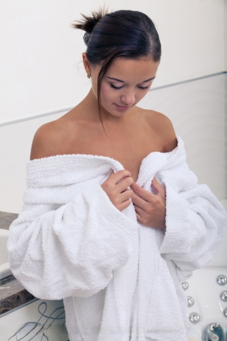 Wet European babe exposing small teen breasts and shaved cunt in bathtub