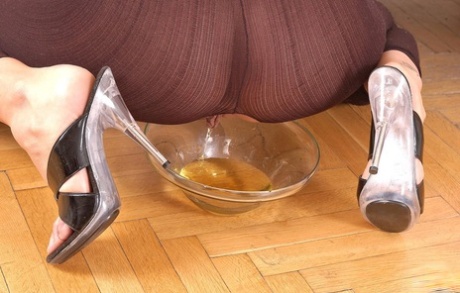 Hot chick Sandy pisses into a glass dish wearing a crotchless bodystocking