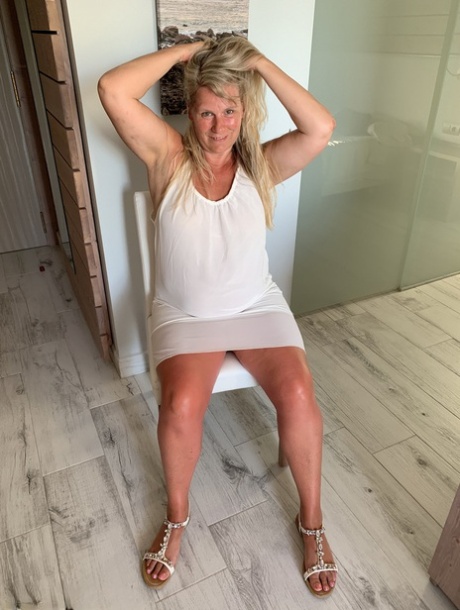 Thick older woman Sweet Susi exposes tan lined tits after hiking up her dress