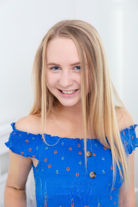 Young looking blonde Layza shows off her tan lined figure while naked on a bed