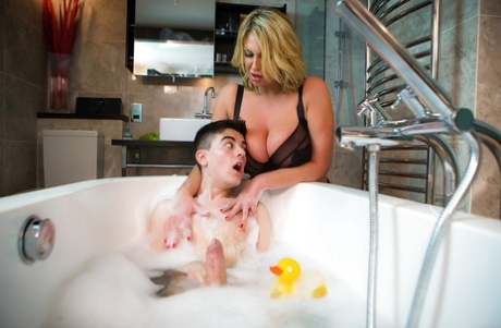 Chesty cougar Leigh Darby giving young boy his first blowjob