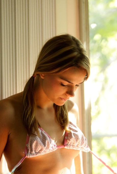 Charming teen Meggan takes off her clothes in poor light