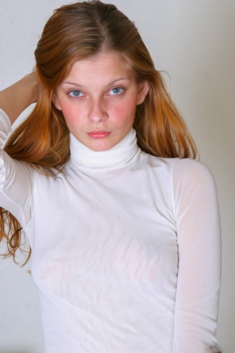 Redheaded beauty Indiana stripping and posing butt naked in a solo