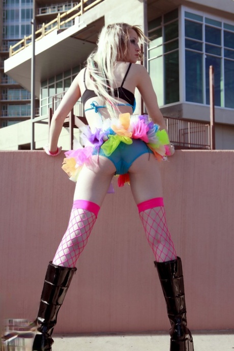 Blonde teen Kiki flashes her perky tits and sexy ass while on a rooftop