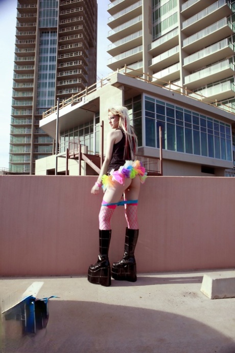 Blonde teen Kiki flashes her perky tits and sexy ass while on a rooftop