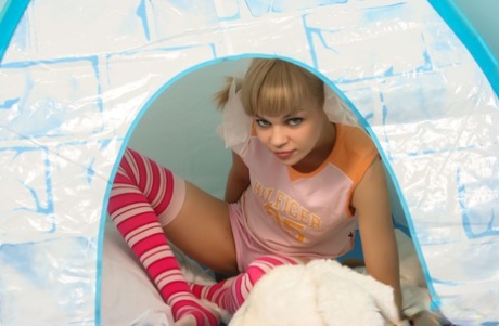 Charming blonde teen Cindy B gets naked inside a tent in striped thigh highs