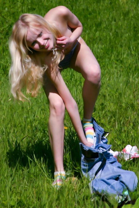 Pretty blonde teen Yana F shows off her petite naked body outdoors