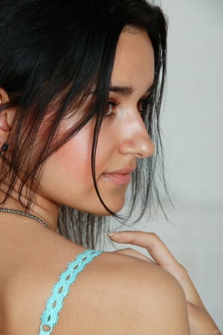 Solo girl with black hair bares her large breasts as she removes her lingerie