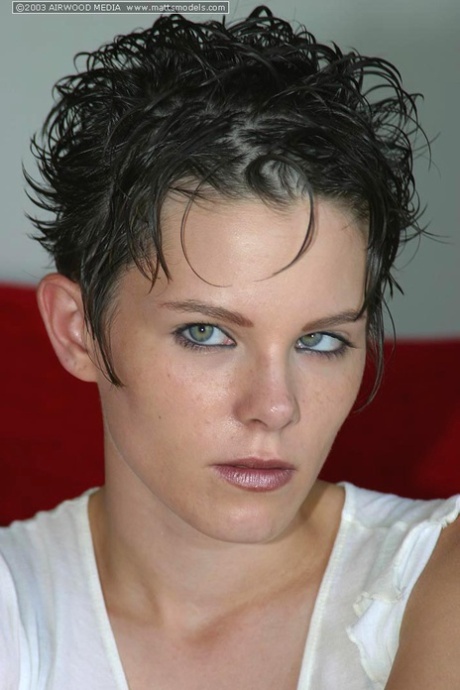 First timer with short hair strips naked on a red sofa for first nude poses