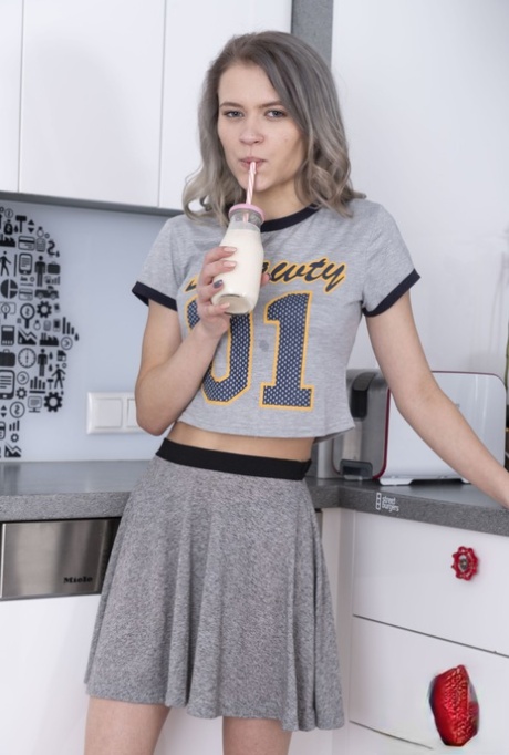 Young Kira J spreads her hairy pussy in the kitchen after a sexy striptease