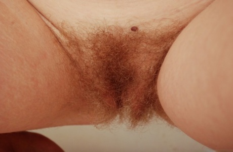 Gorgeous ginger Valcorie squats to show her hairy red pussy close up